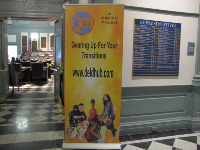 Standing poster announcing DelDHub.com website/ DelDHub Launch in the Delaware Legislative hallway